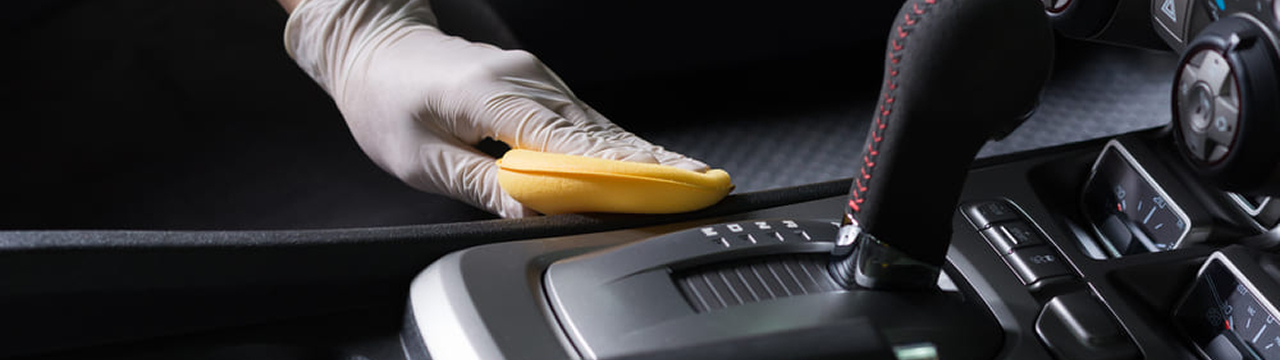 Main gantée polissant une voiture de luxe